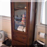 F25. Glass front storage cabinet. 52”h x 20”w x 16”d 